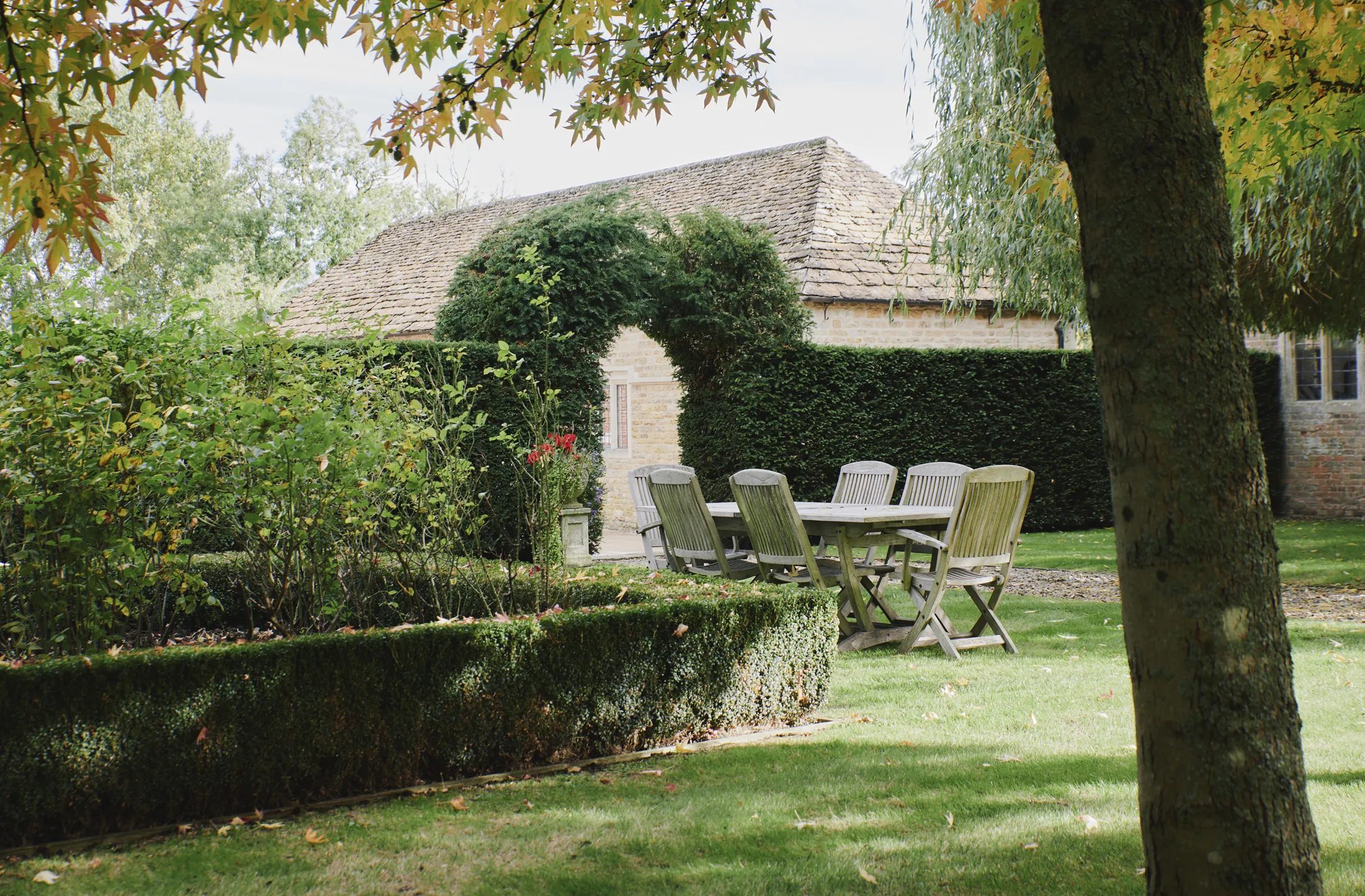 Peaceful garden dining area beneath vine-covered archway at Havenwood, a Domus Stay luxury getaway.
