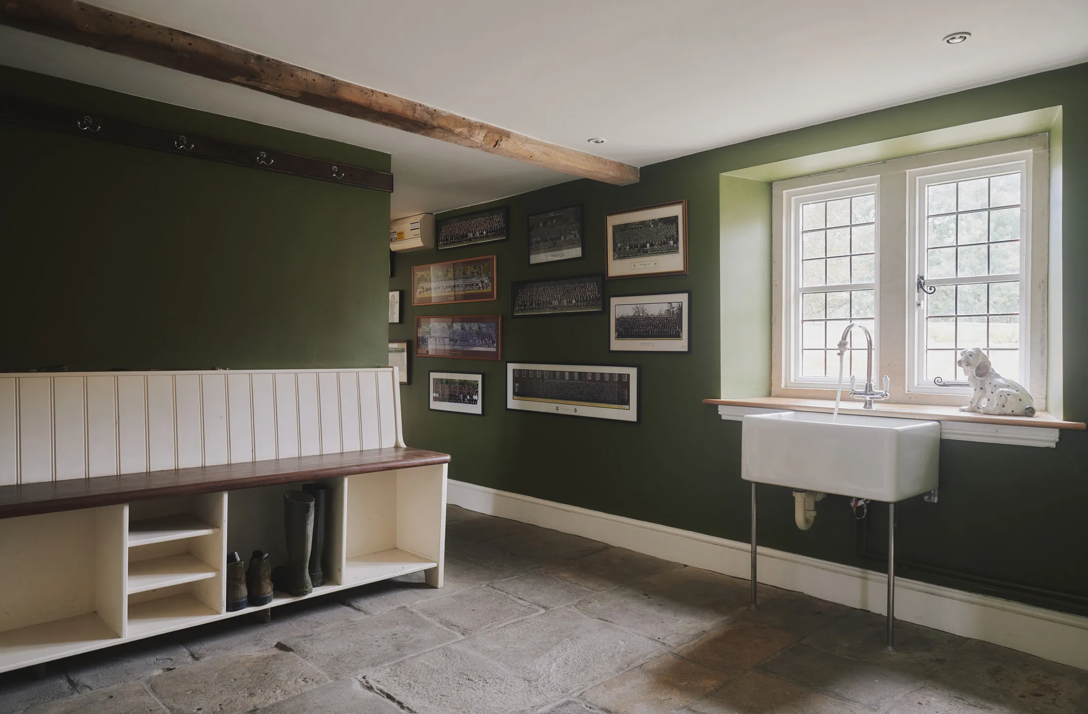 Charming boot room with farmhouse sink and exposed beams at Havenwood, an exclusive short stay rental in The Cotswolds.