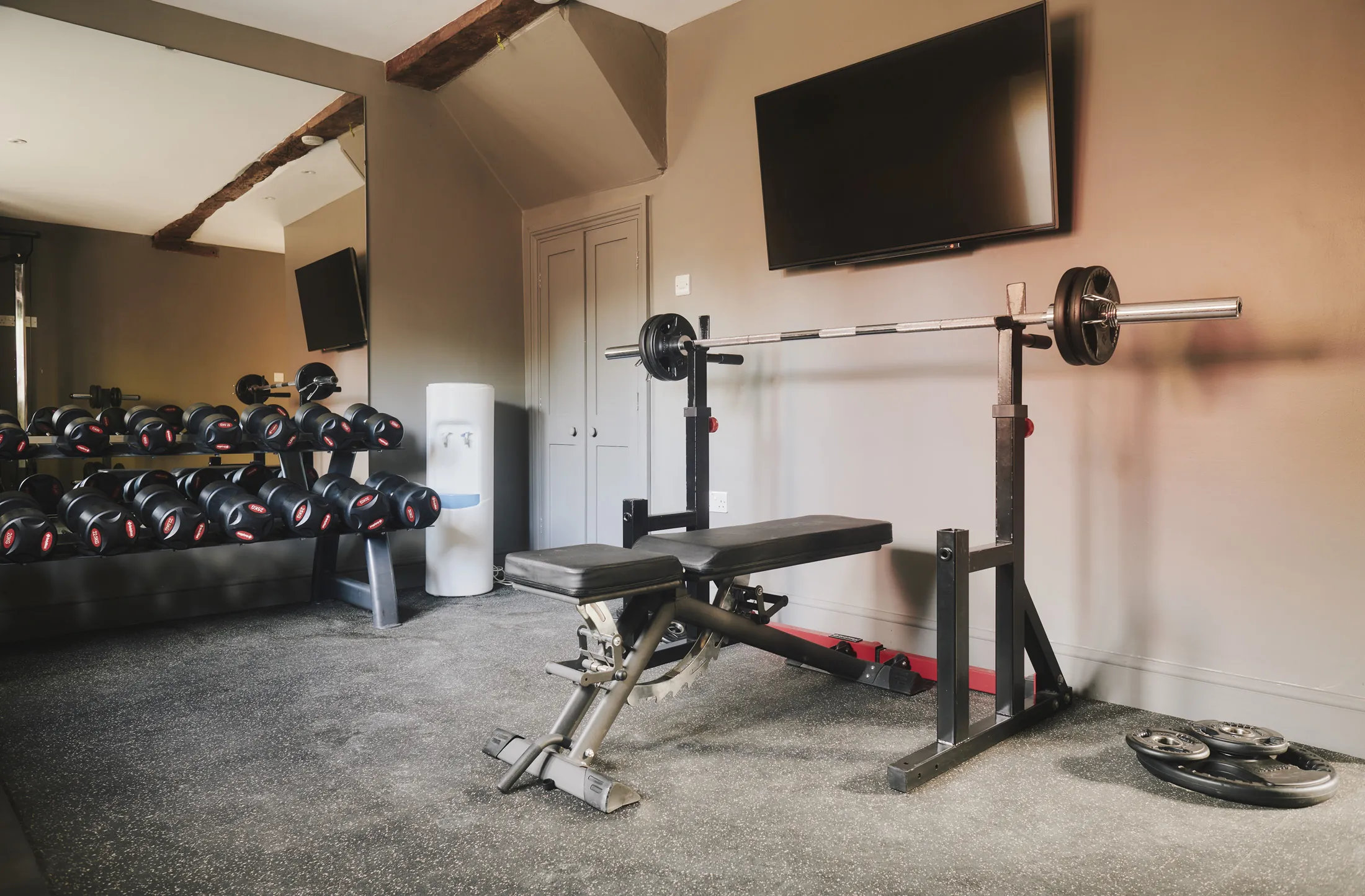 Well-equipped home gym with weights and cardio equipment at Havenwood luxury short term getaway in The Cotswolds.