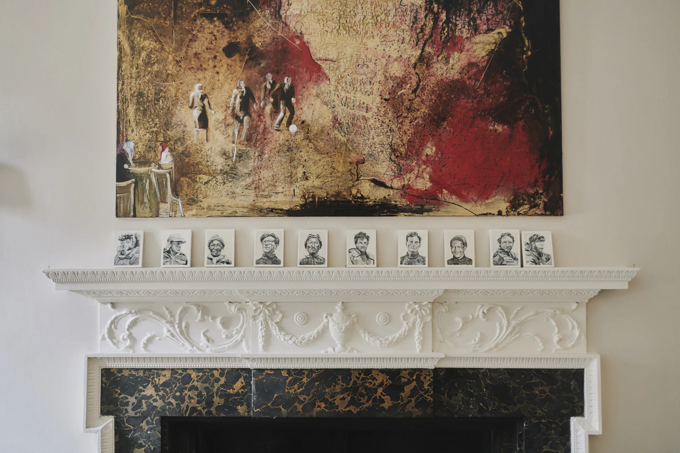 Fireplace with ornate surround beneath oil painting at Havenwood luxury short term getaway in The Cotswolds.