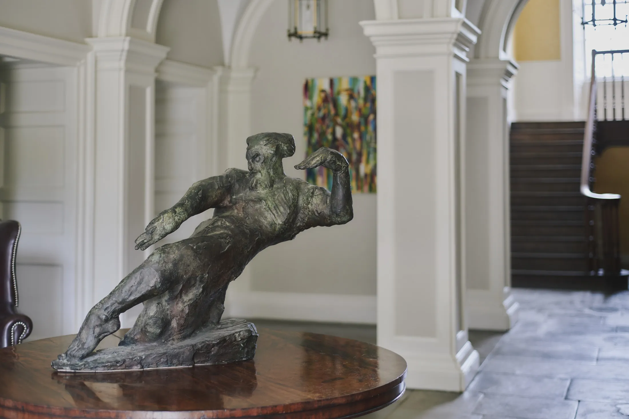 Bronze sculpture on polished console beneath arched doorways in the elegant entrance hall at Havenwood, Domus Stay exclusive countryside property.