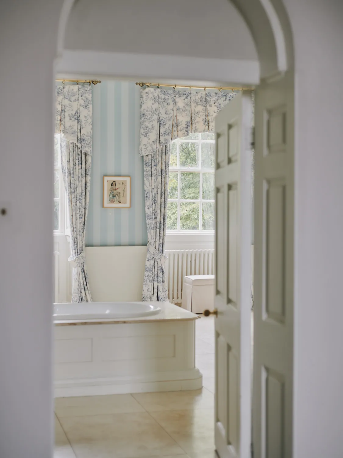 Vintage bathroom with built-in tub and blue striped wallpaper at Havenwood, a Domus Stay luxury getaway.