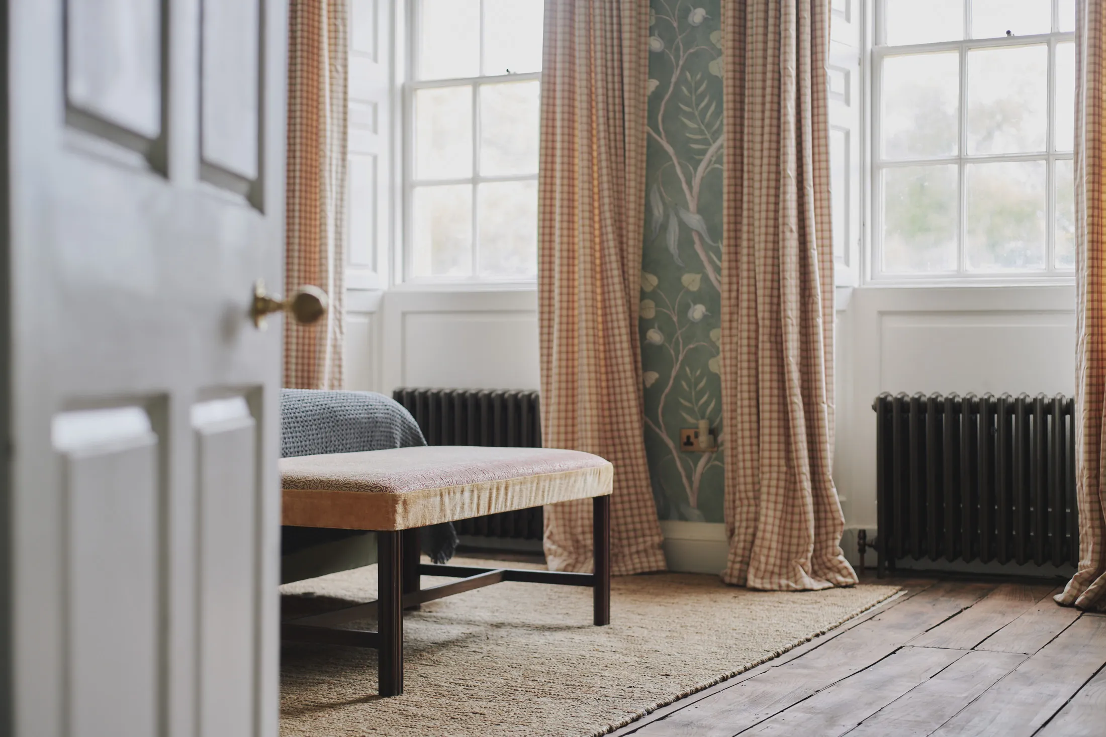 Sun-filled bedroom with floral wallpaper and country plaid curtains at Havenwood, a Domus Stay luxury short stay in The Cotswolds.
