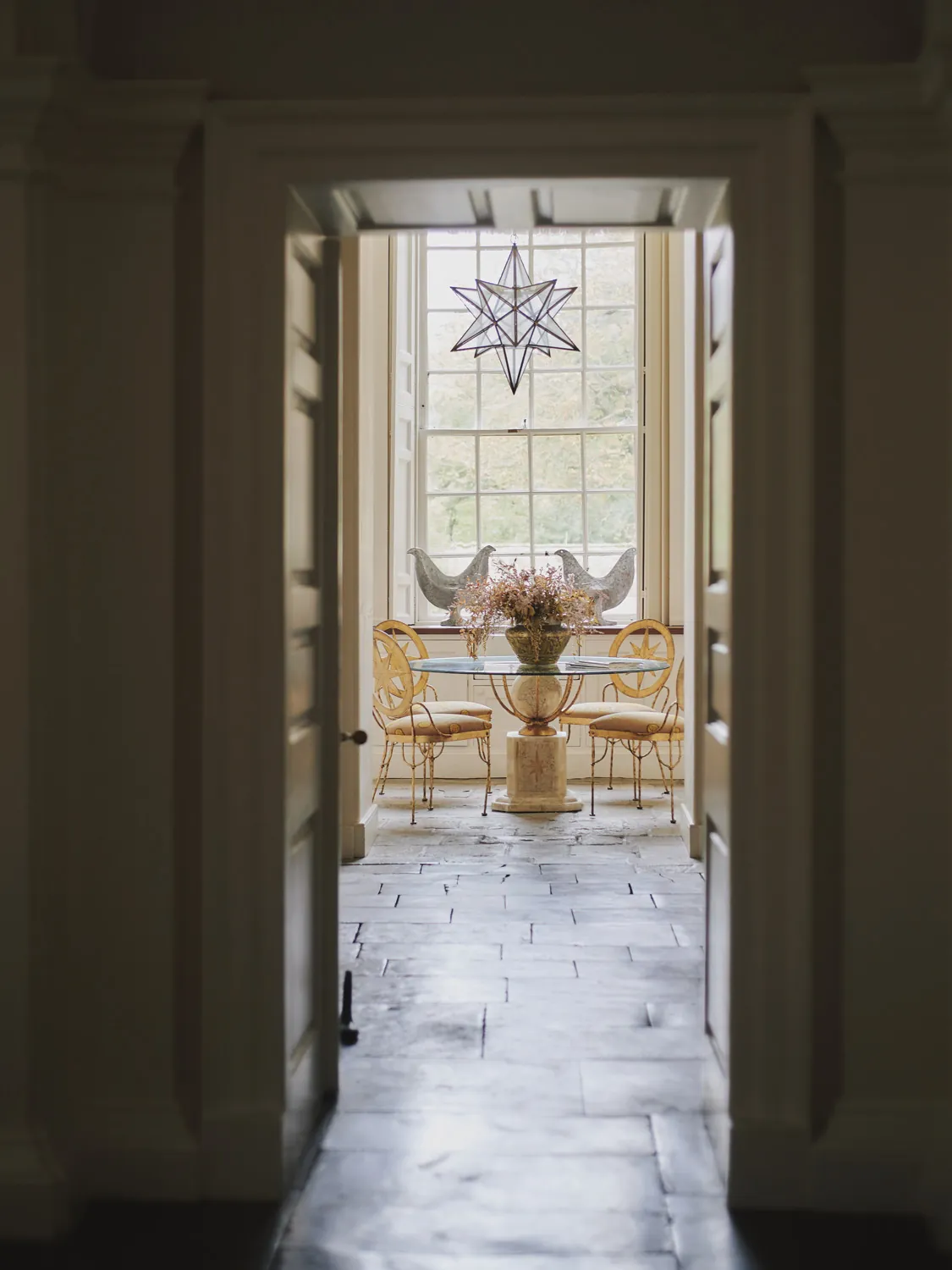 Intimate dining nook with vintage chairs and star pendant at Havenwood exclusive countryside rental in The Cotswolds.