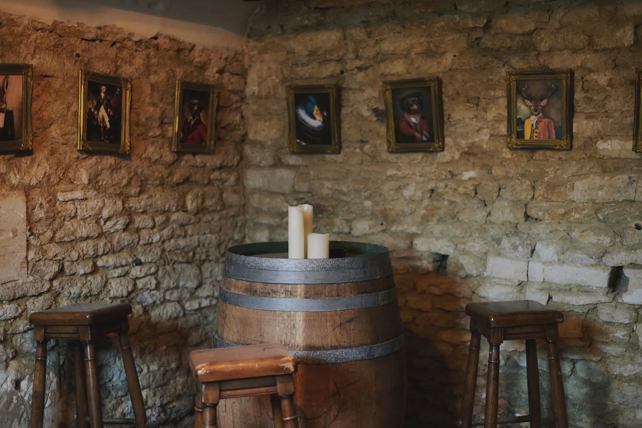Rustic entertaining space with stone walls, barrel table, and candlelight at Havenwood exclusive countryside escape in The Cotswolds.