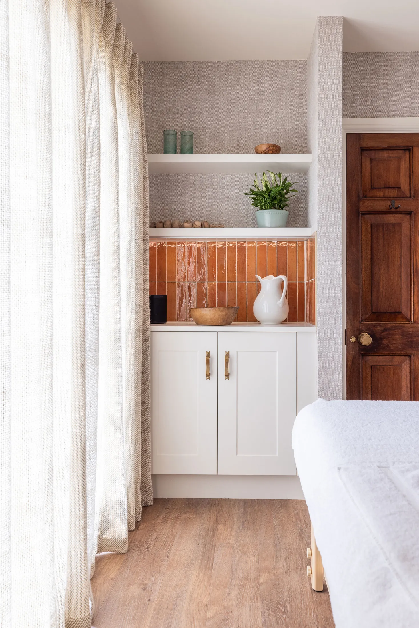 Atmospheric bar lounge at Coombe End, styled with vintage artwork and patterned chairs, offered as a luxury Domus Stay short-term rental in the Cotswolds.