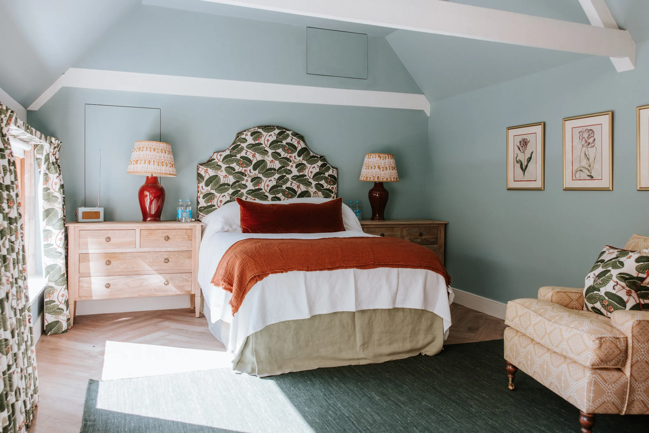 Light and airy bedroom at Coombe End, part of the Domus Stay luxury Cotswolds collection, featuring botanical fabrics, soft blue walls and warm natural light.