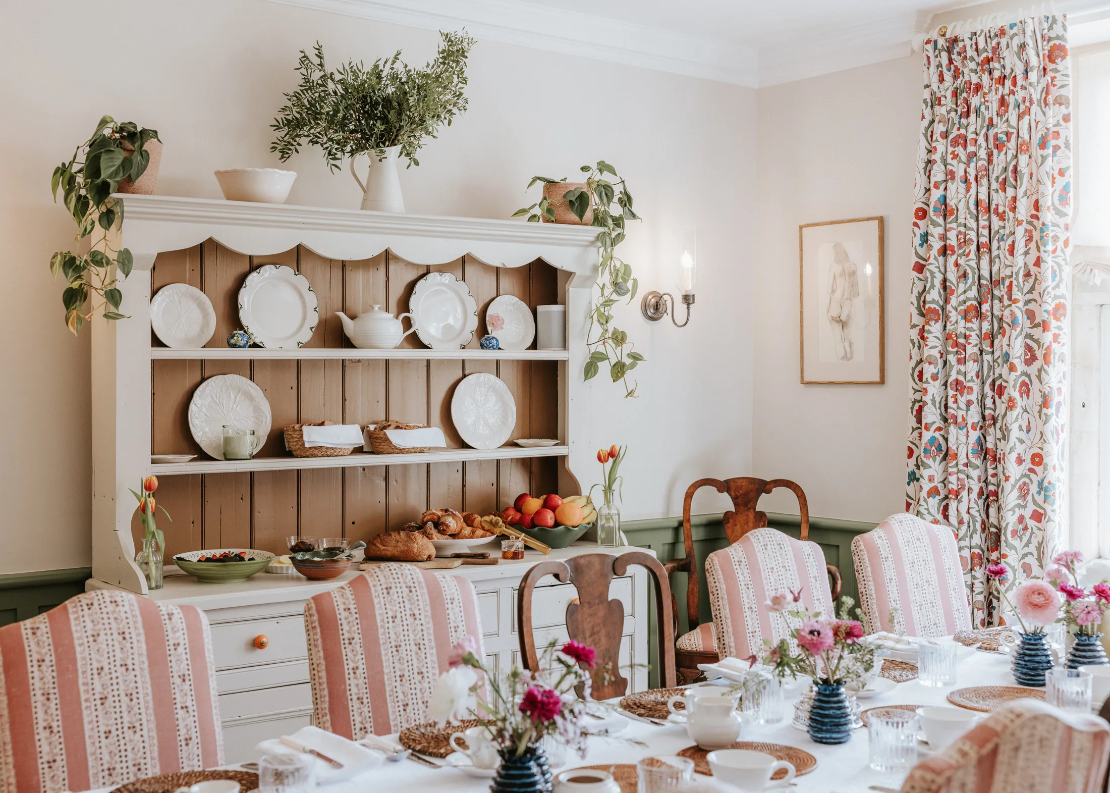 Charming breakfast room at Coombe End, a Domus Stay short-stay property, styled with floral linens, vintage tableware and a traditional dresser.