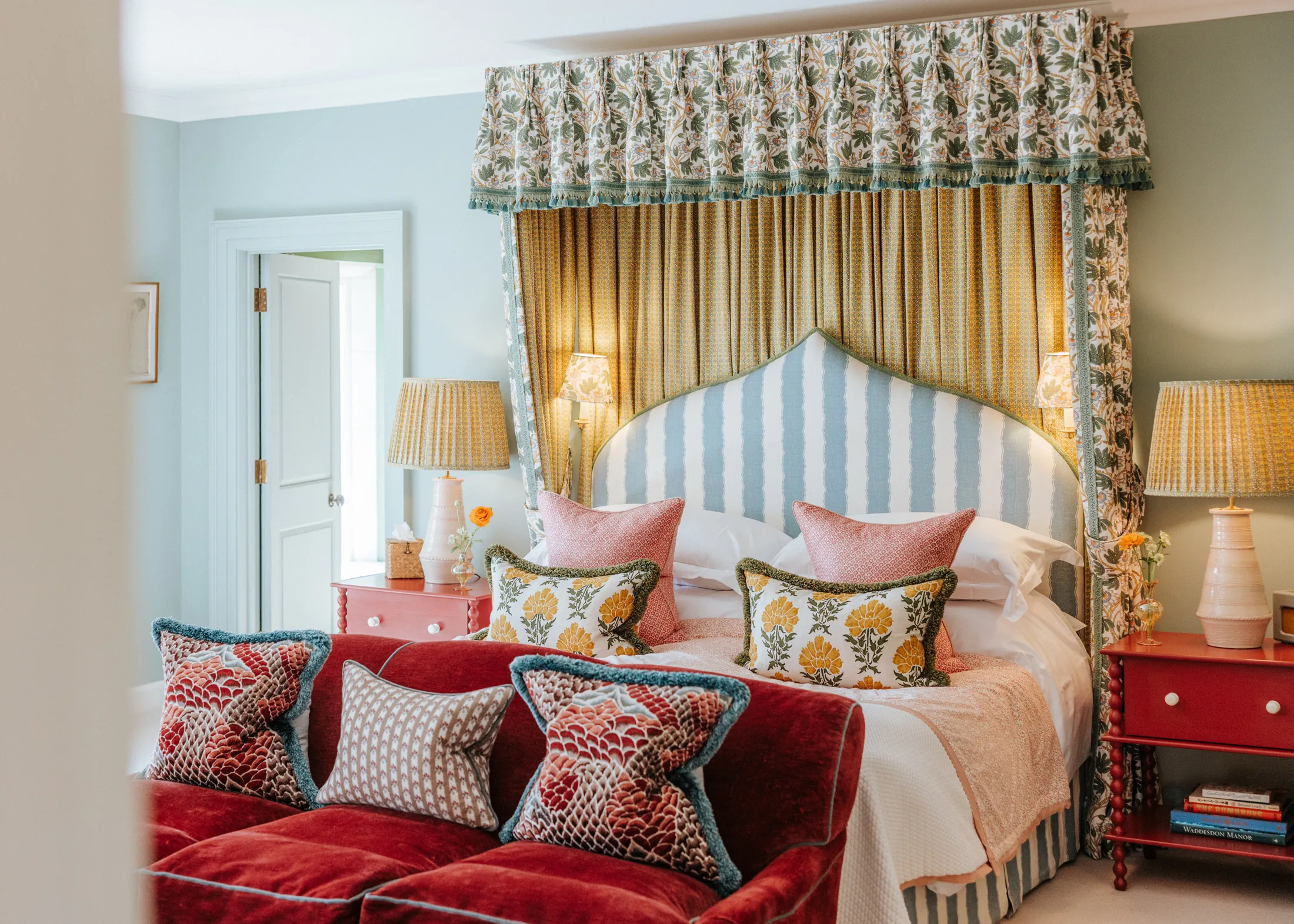 Vibrant bedroom at Coombe End, part of the Domus Stay premium rental portfolio, with a statement canopy bed, patterned fabrics and plush seating.