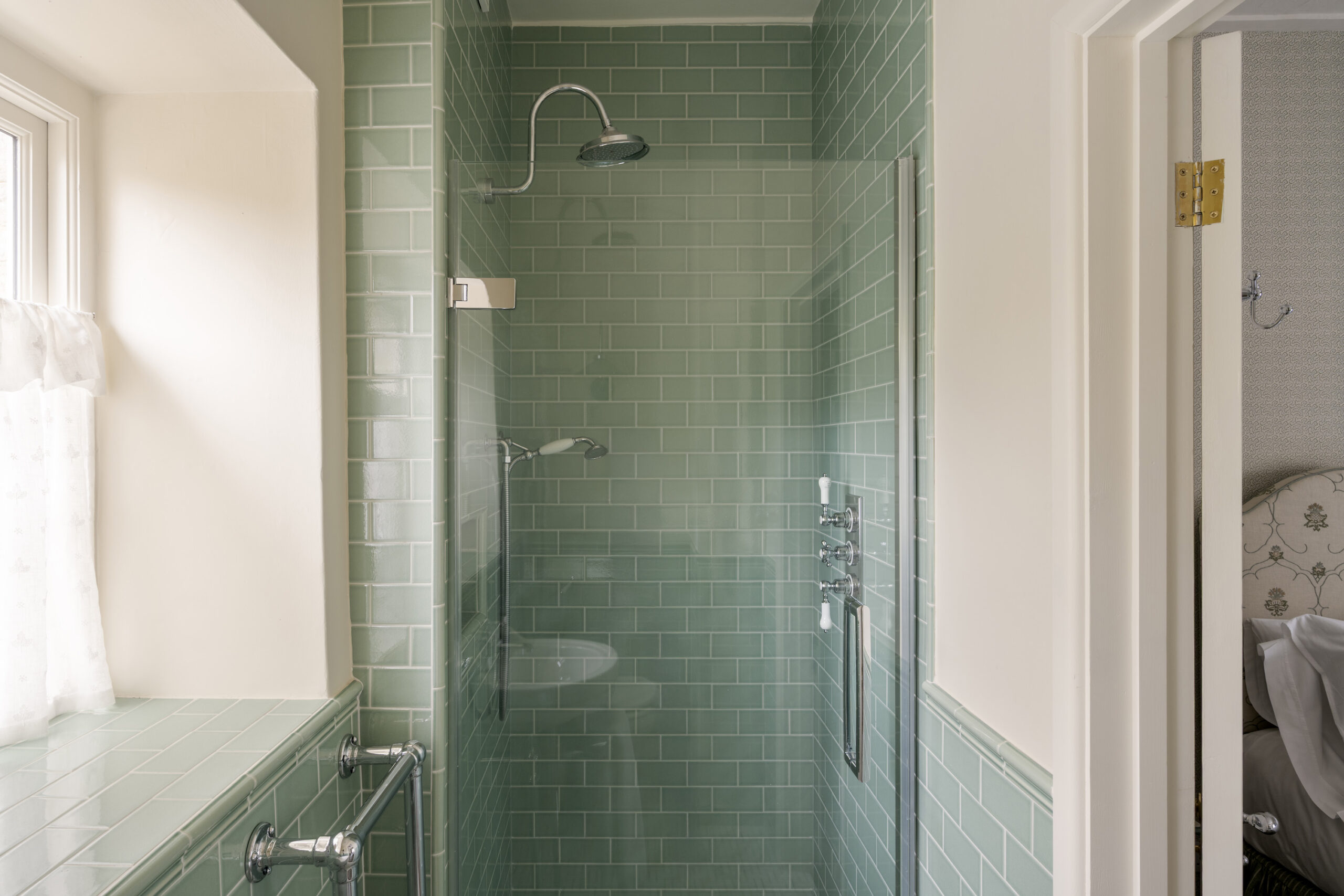 Light-filled shower room with green tiled walls and chrome fittings at Ford Cottage, presented by Domus Stay as a luxury short-stay rental in The Cotswolds.